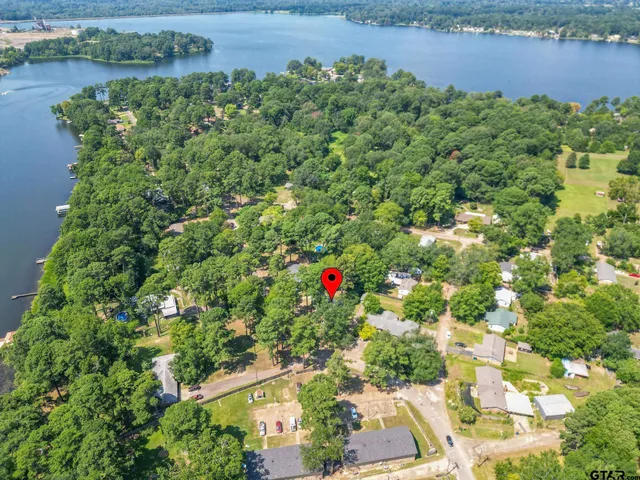 an aerial view of a house with a yard and lake view