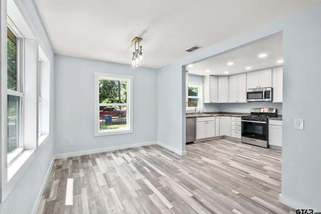 a view of kitchen with wooden floor and electronic appliances