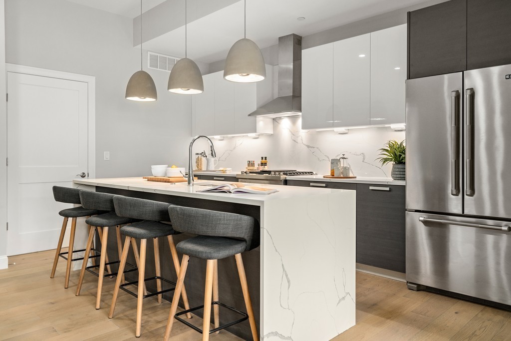a kitchen with granite countertop a table chairs stove and refrigerator
