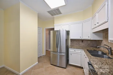 a kitchen with a refrigerator sink and cabinets