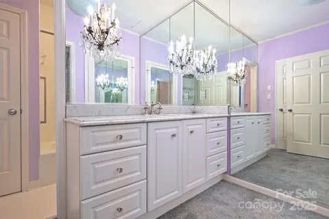 a bathroom with a granite countertop sink a large mirror and a shower