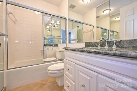 a bathroom with a granite countertop sink a toilet and shower
