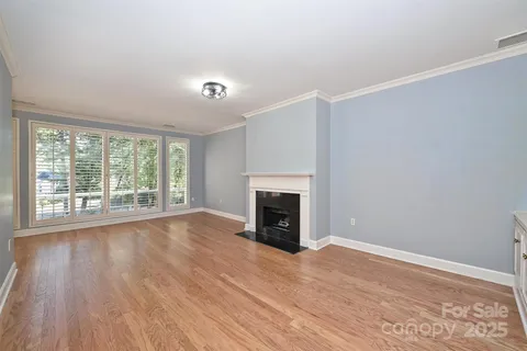 wooden floor fireplace and windows in an empty room