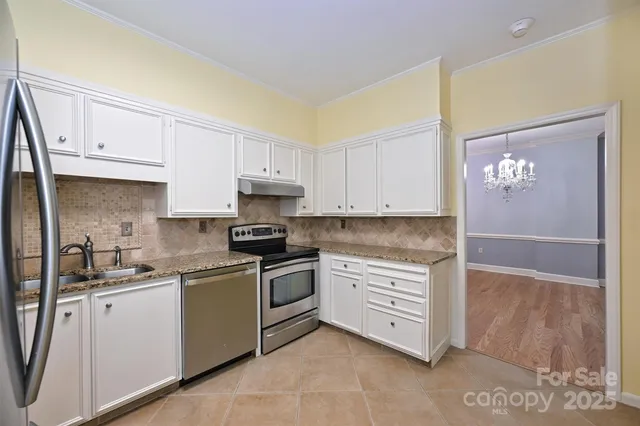 a kitchen with white cabinets stainless steel appliances and sink