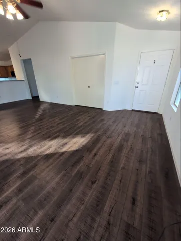 a view of empty room with wooden floor