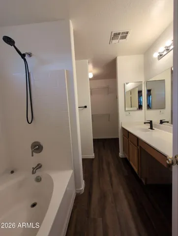 a bathroom with a tub a sink and mirrors