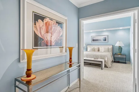 a bedroom with furniture and a painting on the wall