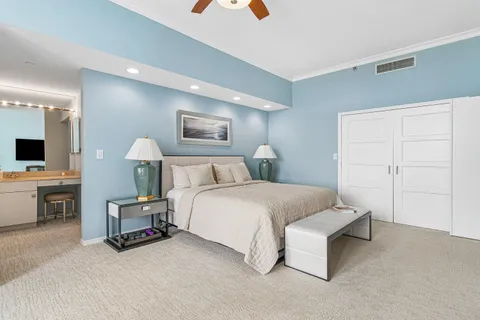 a spacious bedroom with a bed and a flat screen tv
