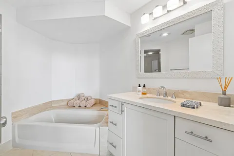 a bedroom with a bed and a large mirror on the dresser
