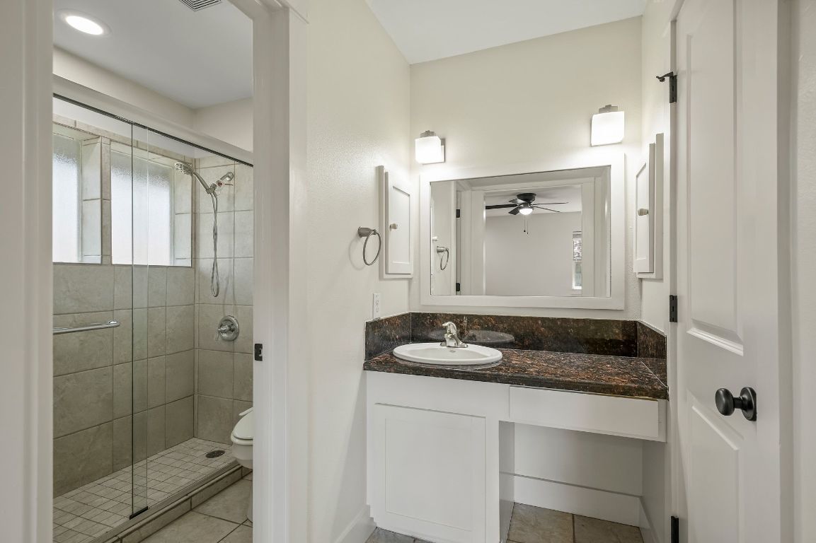 7202 Running Rope Circle Austin, TX 78731 - Photo 25 of 40 a bathroom with a granite countertop sink and a mirror