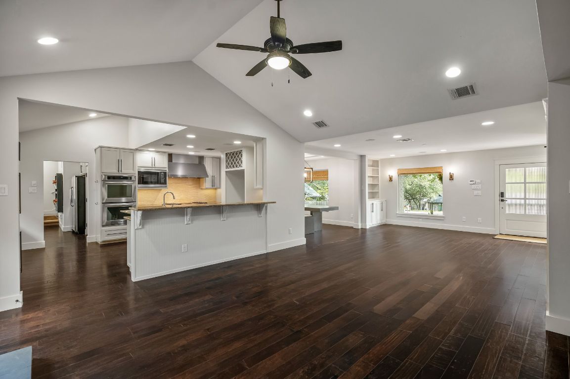 7202 Running Rope Circle Austin, TX 78731 - Photo 7 of 40 a view of an empty room and kitchen with wooden floor