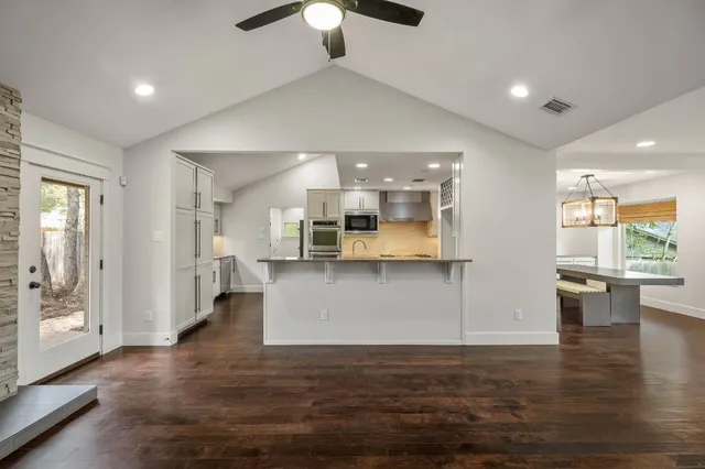 a kitchen with stainless steel appliances granite countertop a refrigerator a stove and a sink