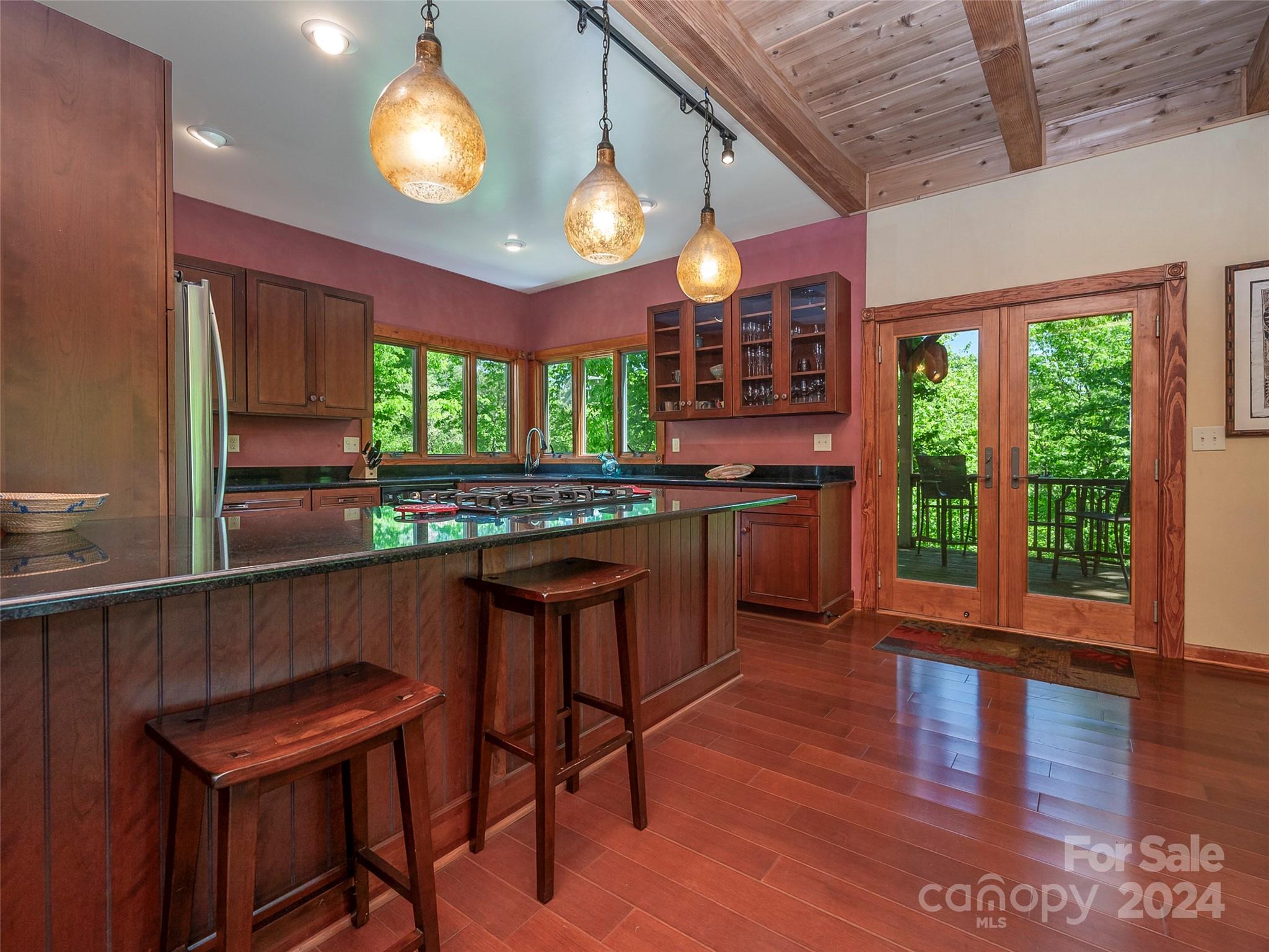 58 Next To The Last Road Saluda, NC 28773 - Photo 11 of 48 a kitchen with stainless steel appliances granite countertop wooden cabinets a stove a sink and a large window