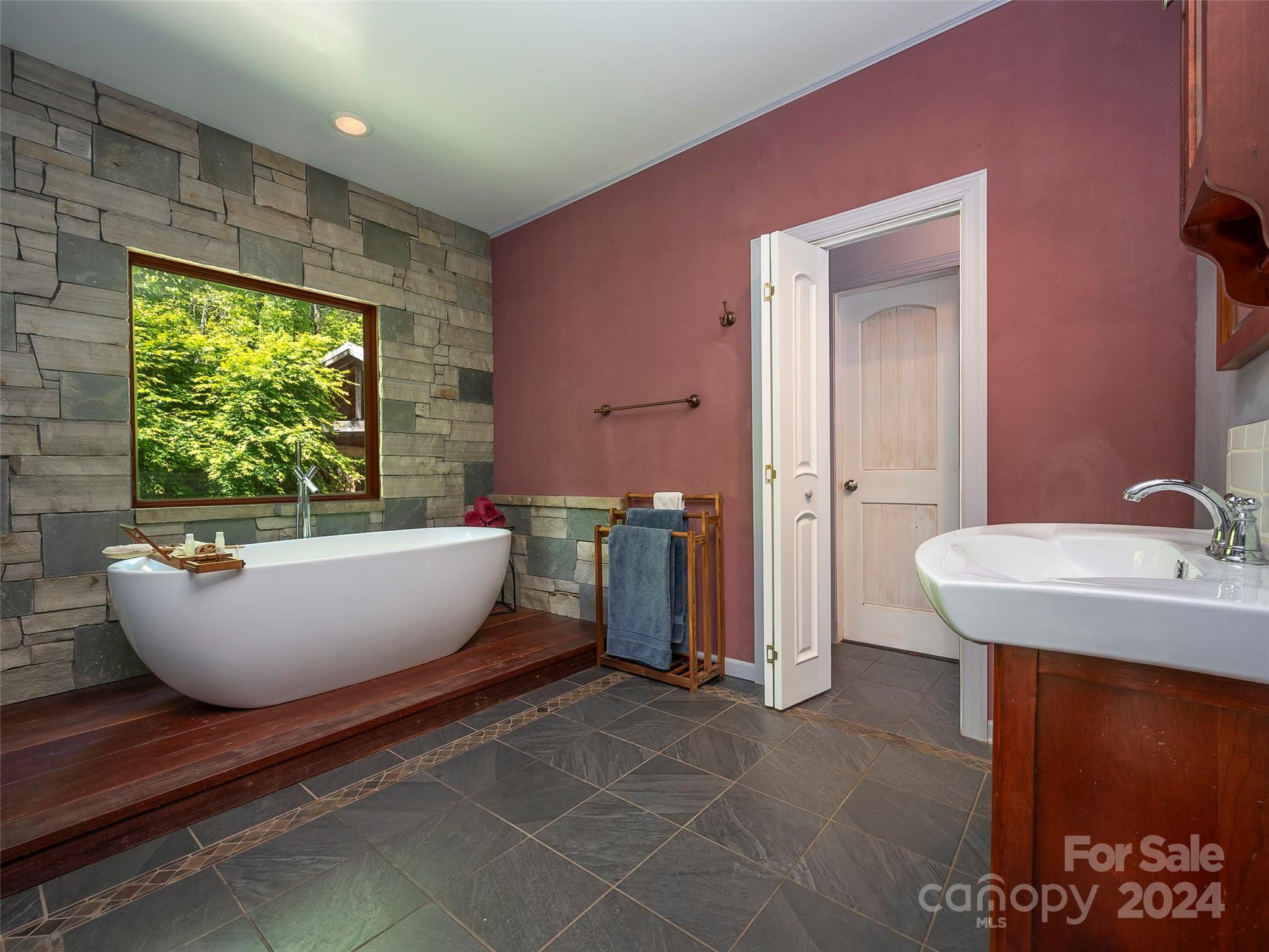58 Next To The Last Road Saluda, NC 28773 - Photo 22 of 48 a white bath tub sitting in a bathroom next to a window