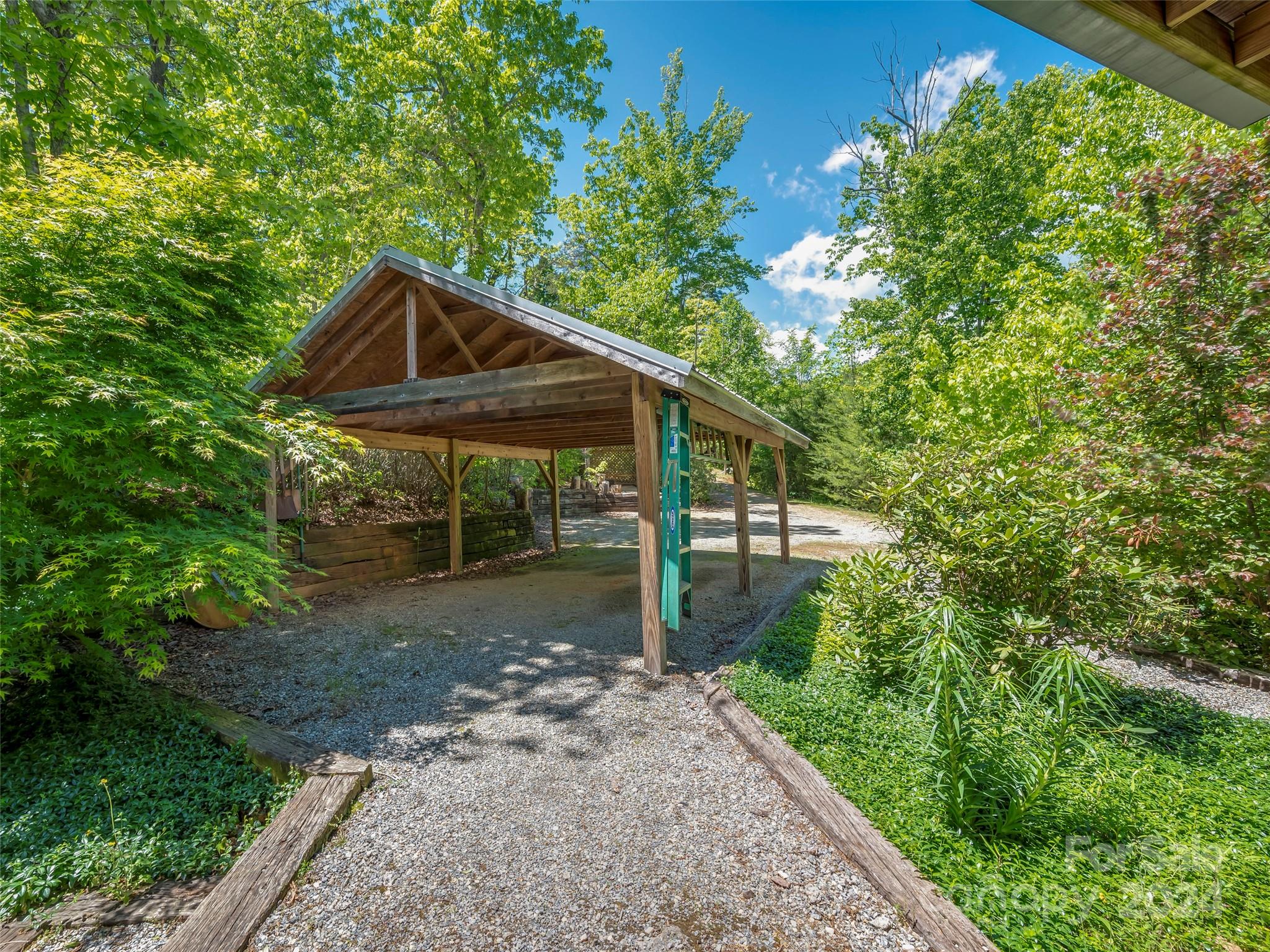 58 Next To The Last Road Saluda, NC 28773 - Photo 42 of 48 a view of a small house with a small yard plants and large tree
