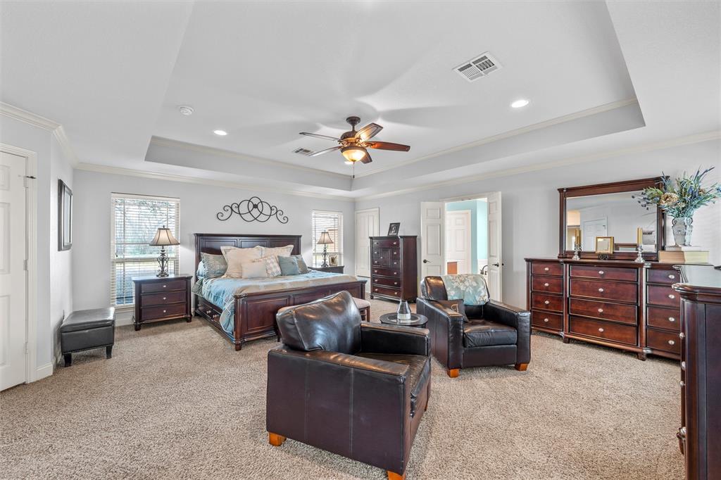 231 Trlica Road West, TX 76691 - Photo 14 of 36 a bedroom with a large bed and a chandelier