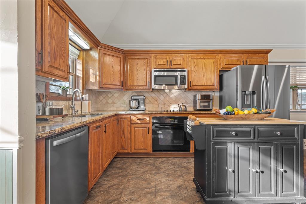 231 Trlica Road West, TX 76691 - Photo 9 of 36 a kitchen with stainless steel appliances granite countertop a stove a sink dishwasher and a refrigerator