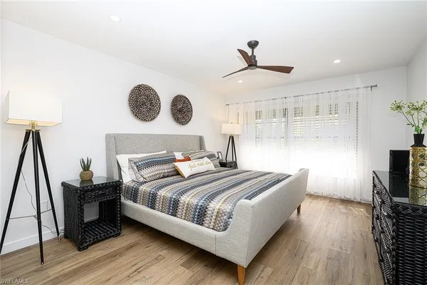 a bedroom with a bed and a flat tv screen on a dresser