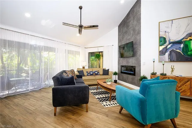 a living room with furniture a flat screen tv and a fireplace