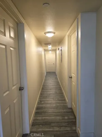 a view of a hallway with wooden floor and staircase