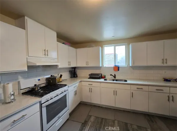 a kitchen with sink a stove and cabinets