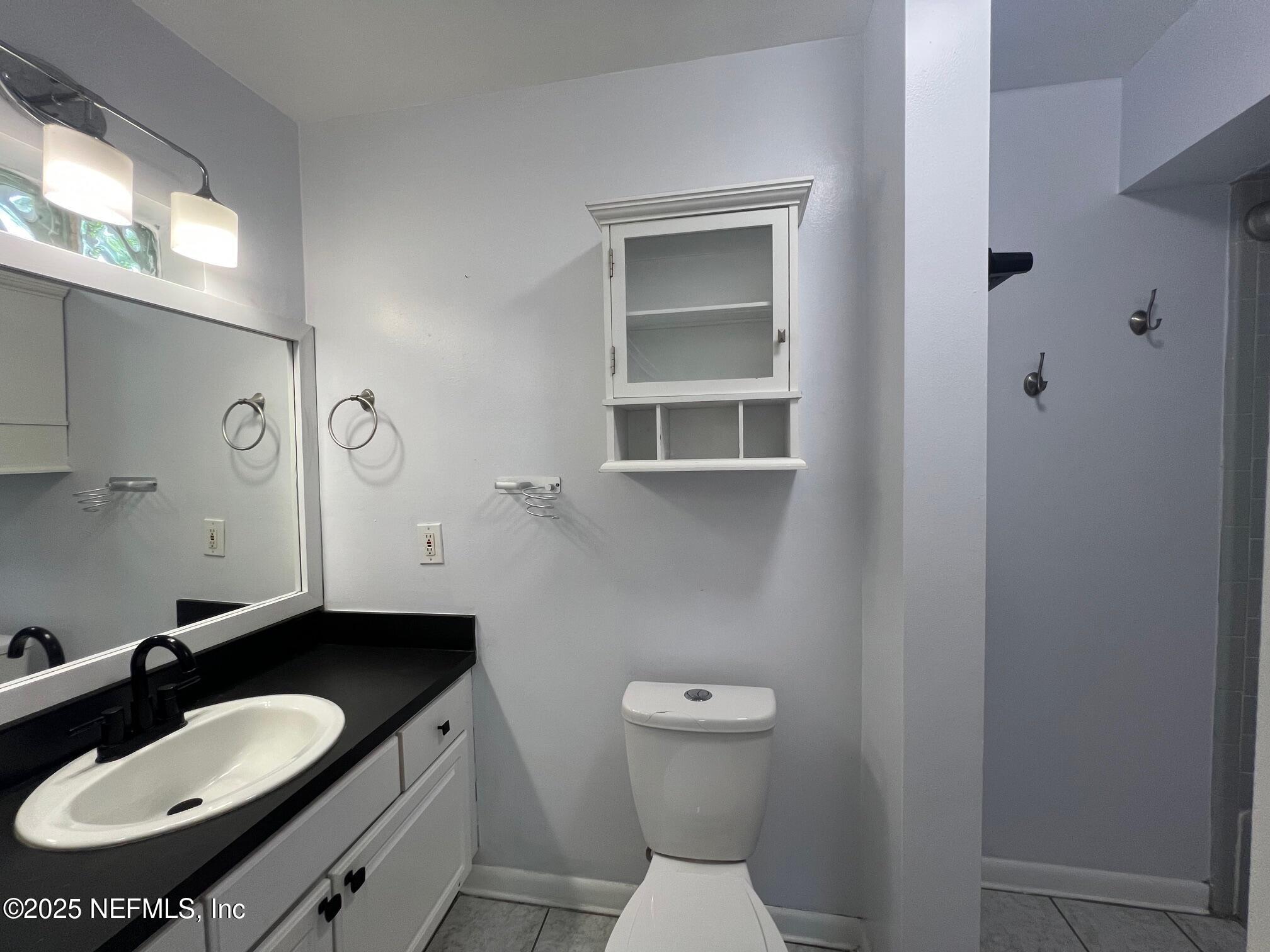 6231 Riviera Manor Drive Jacksonville, FL 32216 - Photo 12 of 15 a bathroom with a granite countertop toilet a sink and a mirror