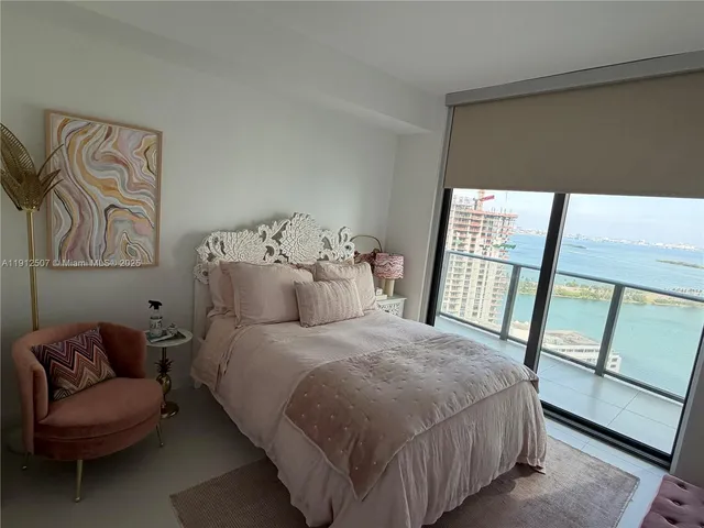 a bedroom with a bed and a large window