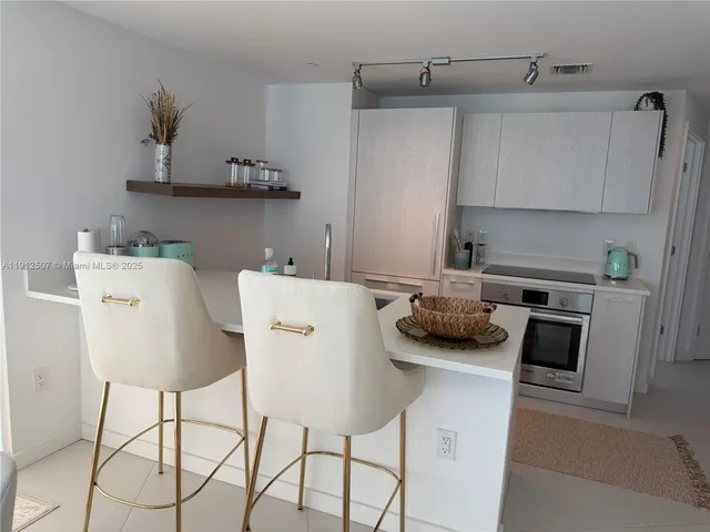 a kitchen with stainless steel appliances a stove a sink and cabinets