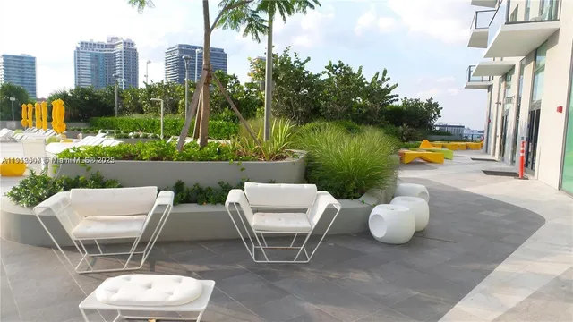 a view of a patio with a table and chairs and potted plants