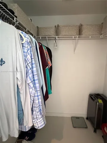 a view of walk in closet with clothes and shoes