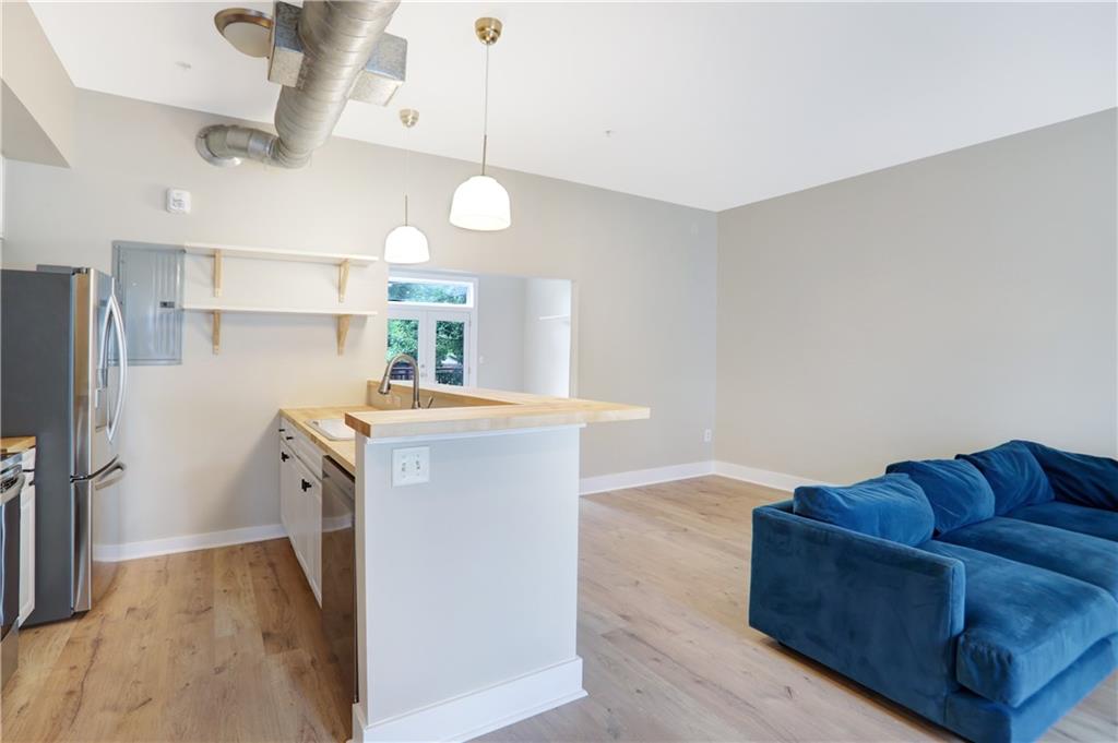 a living room with stainless steel appliances kitchen island granite countertop furniture and a fireplace