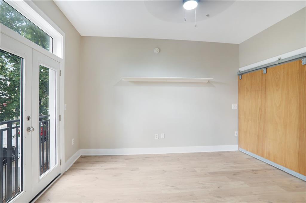 502 Pryor Street Southwest, Unit 113 Atlanta, GA 30312 - Photo 11 of 21 a view of an empty room with wooden floor and a window