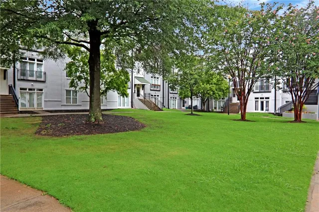 a front view of a house with garden and trees