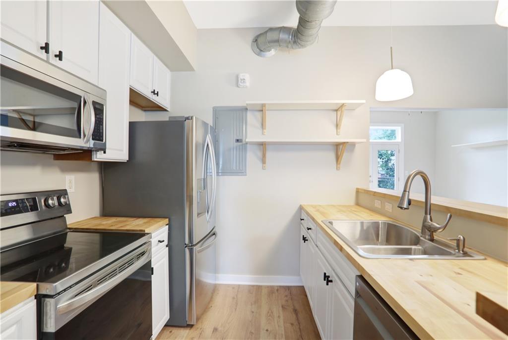 502 Pryor Street Southwest, Unit 113 Atlanta, GA 30312 - Photo 3 of 21 a kitchen with stainless steel appliances granite countertop a sink stove and refrigerator