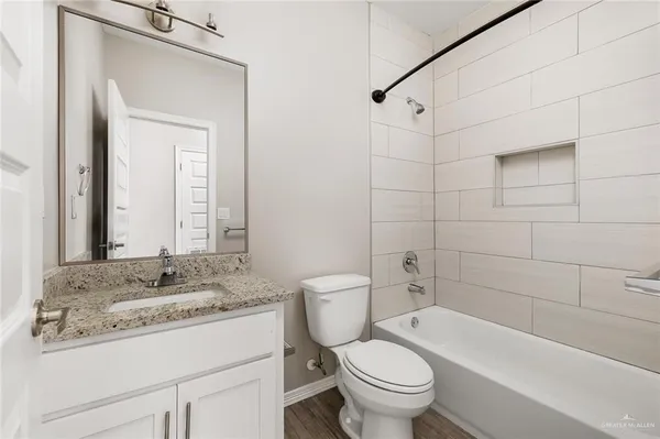 a bathroom with a granite countertop toilet a sink and a bathtub
