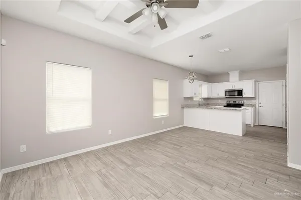 a view of kitchen with granite countertop stainless steel appliances cabinets a sink and a window