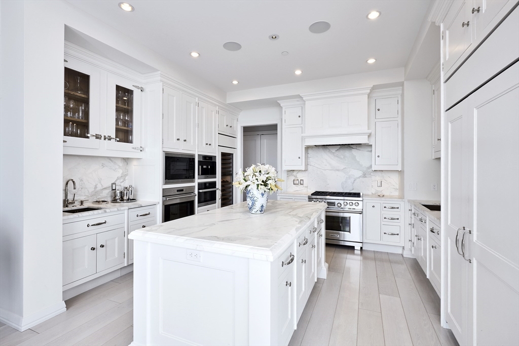 1 Franklin Street, Unit PH1B Boston, MA 02110 - Photo 11 of 42 a large kitchen with stainless steel appliances kitchen island granite countertop a stove and a sink