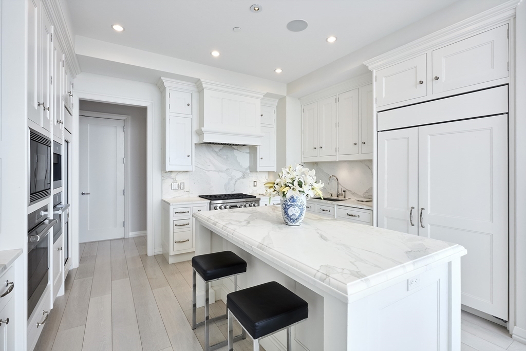 1 Franklin Street, Unit PH1B Boston, MA 02110 - Photo 12 of 42 a kitchen with stainless steel appliances granite countertop a stove a refrigerator a sink a stove and white cabinets