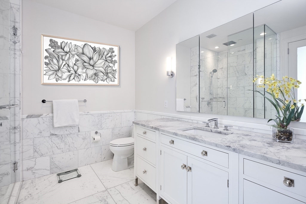 1 Franklin Street, Unit PH1B Boston, MA 02110 - Photo 22 of 42 a bathroom with a granite countertop sink mirror and toilet