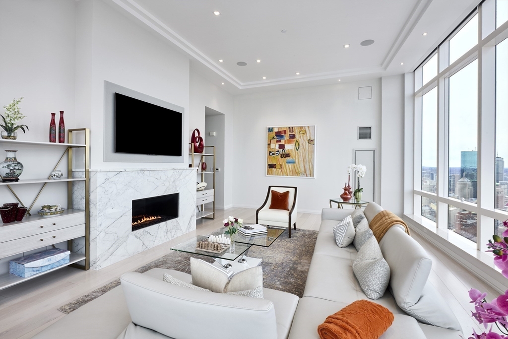 1 Franklin Street, Unit PH1B Boston, MA 02110 - Photo 8 of 42 a living room with furniture a fireplace and a flat screen tv