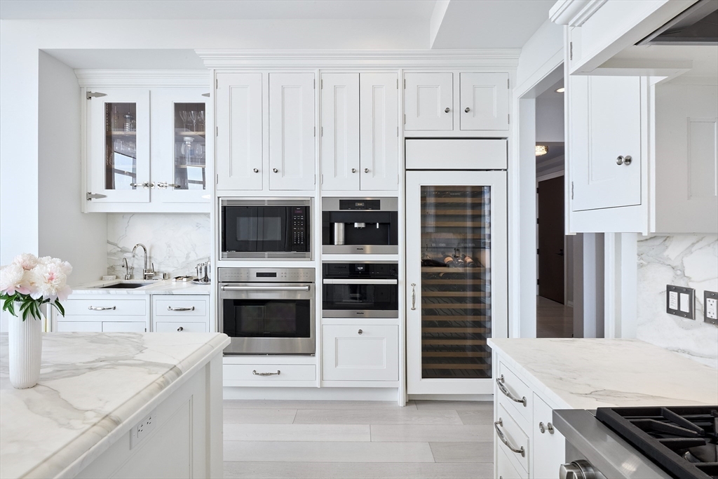 1 Franklin Street, Unit PH1B Boston, MA 02110 - Photo 10 of 42 a kitchen with stainless steel appliances a stove a white cabinets and a potted plant
