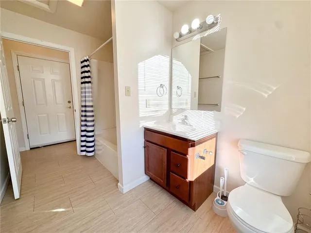 a bathroom with a granite countertop sink mirror vanity and toilet