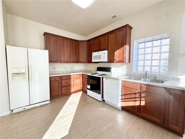 a kitchen with stainless steel appliances a refrigerator sink and cabinets