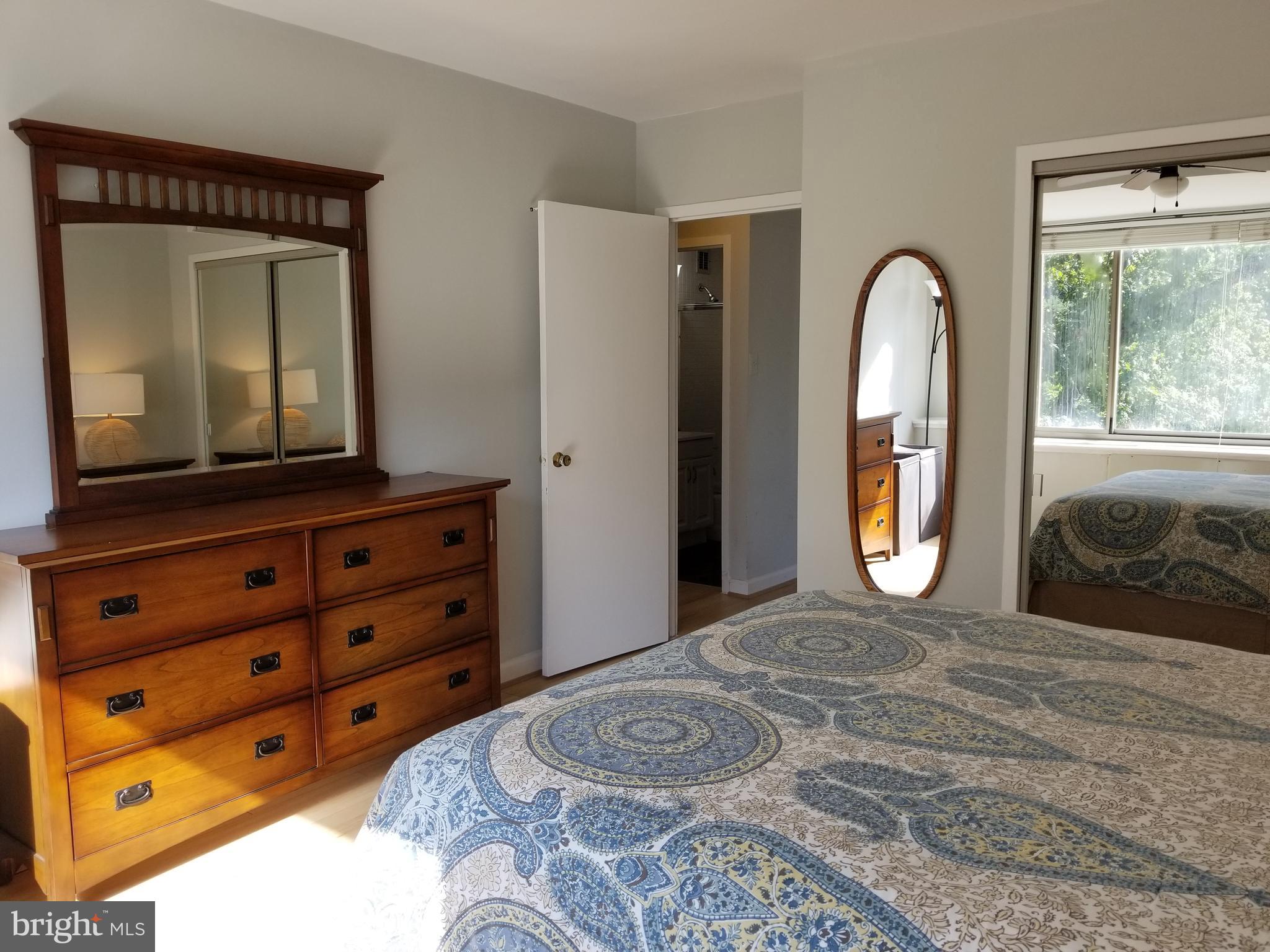 1111 Arlington Boulevard, Unit 307 Arlington, VA 22209 - Photo 18 of 36 a bedroom with a bed and a mirror on dresser