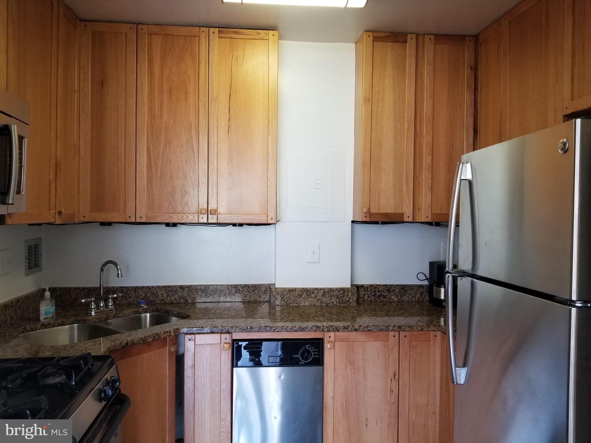 1111 Arlington Boulevard, Unit 307 Arlington, VA 22209 - Photo 2 of 36 a kitchen with stainless steel appliances granite countertop a refrigerator a sink dishwasher with a stove and white cabinets