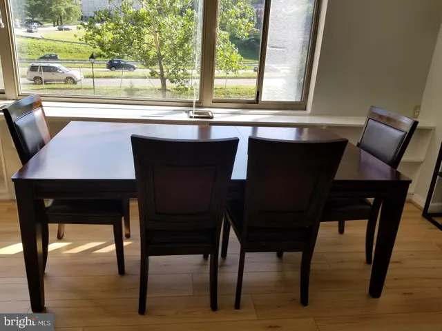 a kitchen with a table chairs and wooden floor