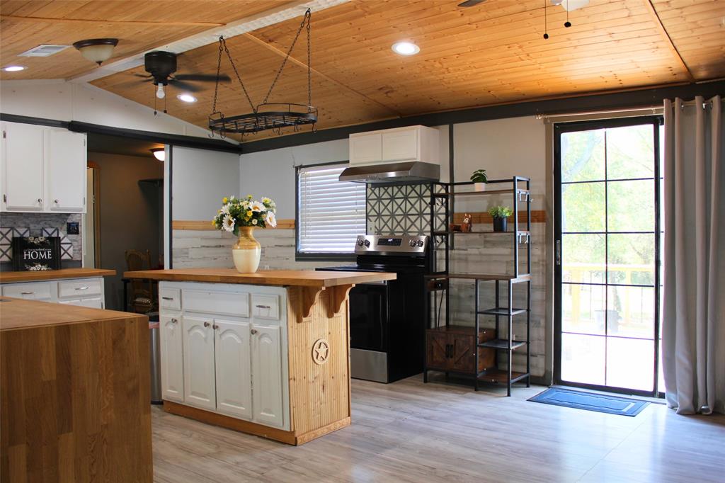 12608 Valverde Loop Terrell, TX 75161 - Photo 4 of 26 a kitchen with stainless steel appliances kitchen island granite countertop a refrigerator and a stove top oven