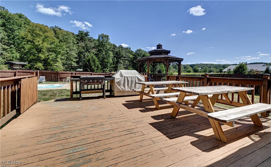 5747 Middle Run Road Dover, OH 44622 - Photo 26 of 30 Wooden deck with a fenced backyard, a gazebo, and outdoor dining space