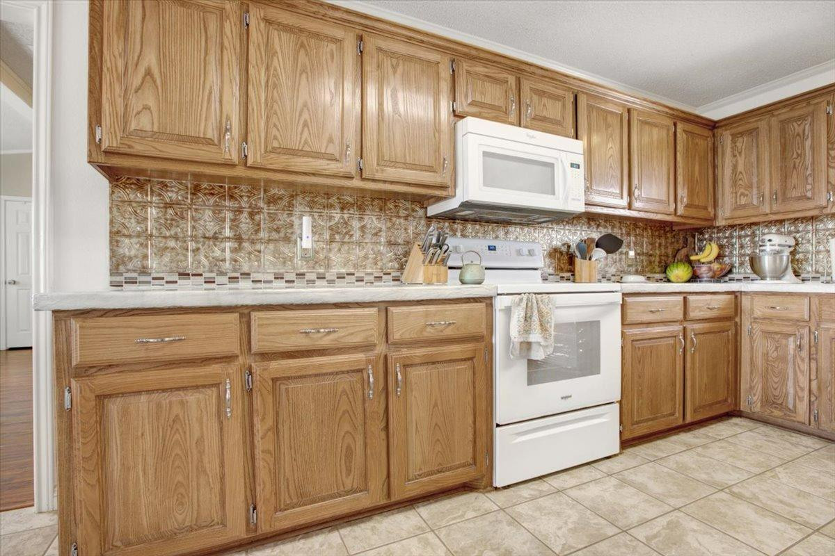 1703 Owl Road Lubbock, TX 79407 - Photo 11 of 33 a kitchen with stainless steel appliances granite countertop a sink and dishwasher with white cabinets