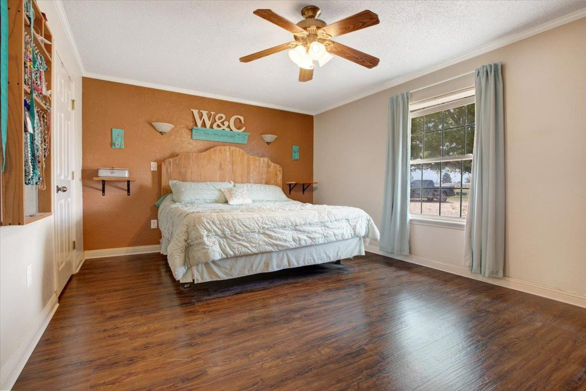1703 Owl Road Lubbock, TX 79407 - Photo 13 of 33 a bedroom with a bed and wooden floor